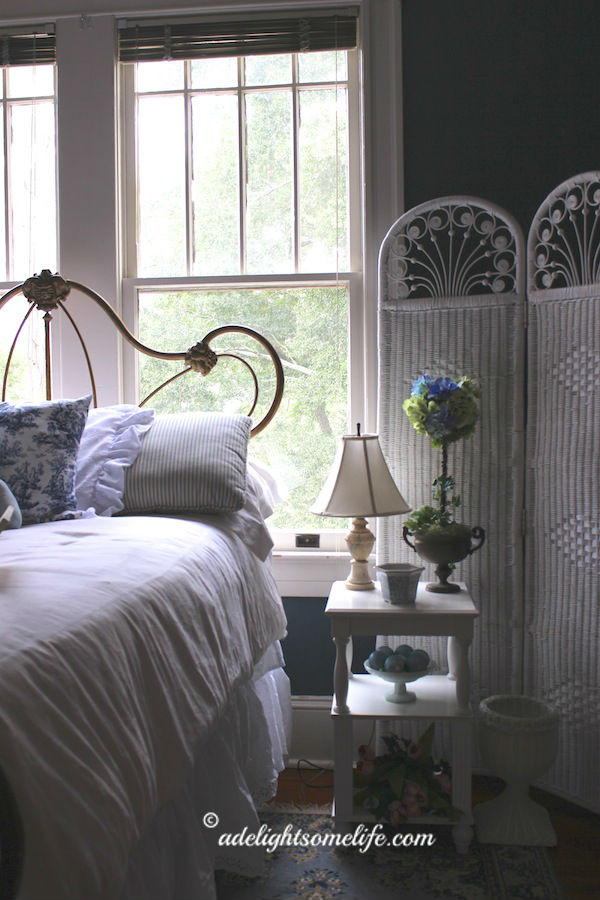 cast iron bed, blue bedroom, blue and white decor, alabaster lamp, wicker screen