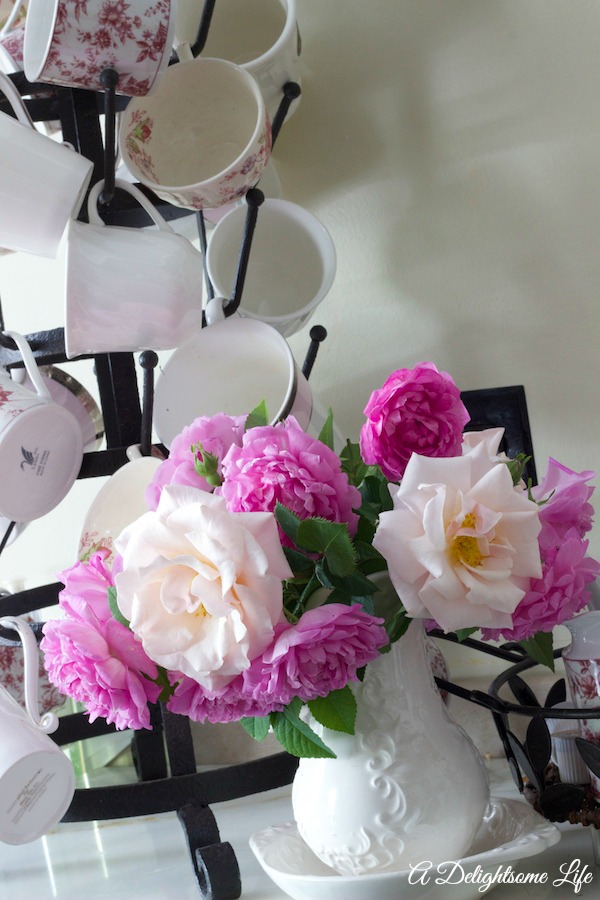 A DELIGHTSOME LIFE FRENCH BOTTLE RACK TEACUPS AND ROSES