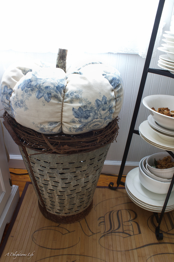 large blue and white pumpkin on olive bucket for autumn decor a delightsome life