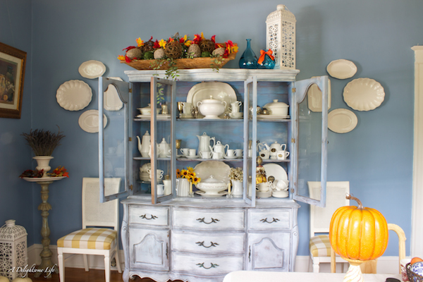 White Tea Set in china cabinet. White platters from Decor Steals. Blue dining room